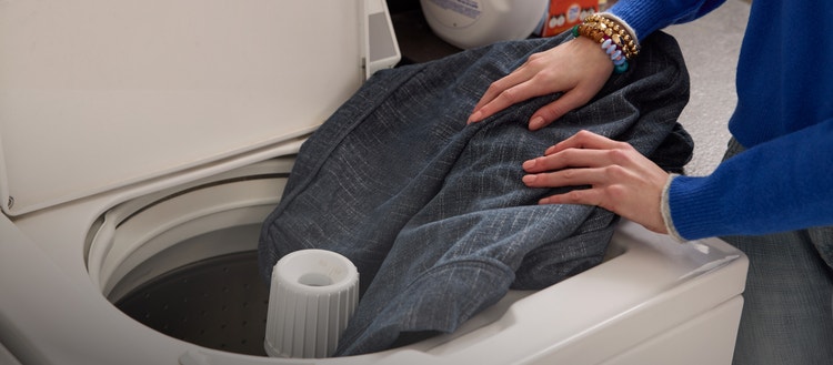 Person cleaning Lovesac fabric in a washing machine