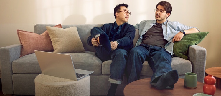 People relaxing on a grey, Lovesac, Snugg 2-Cushion Sofa