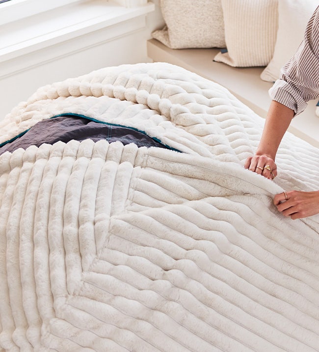 Woman changing her Lovesac beanbag chair cover.