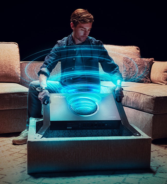 Woman using a brown, Lovesac, sectional couch with a storage seat.
