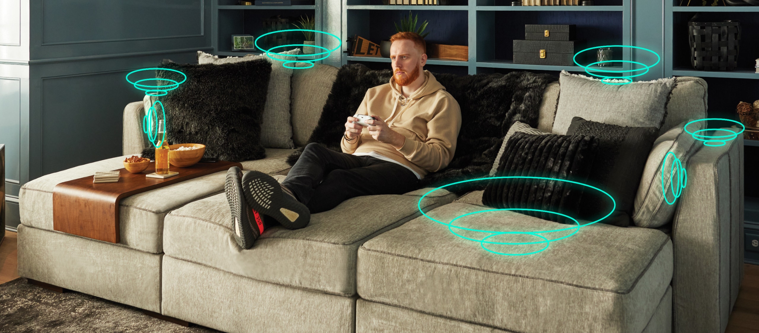 Man playing Xbox game on Lovesac couch with StealthTech Sound and Charge