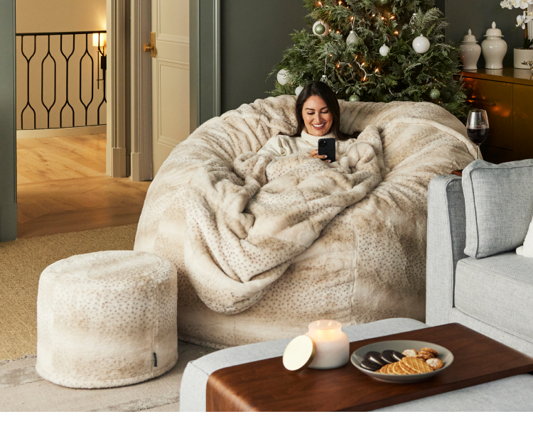 Woman relaxing on a Lovesac Bean Bag chair with Squattoman and Footsac blanket