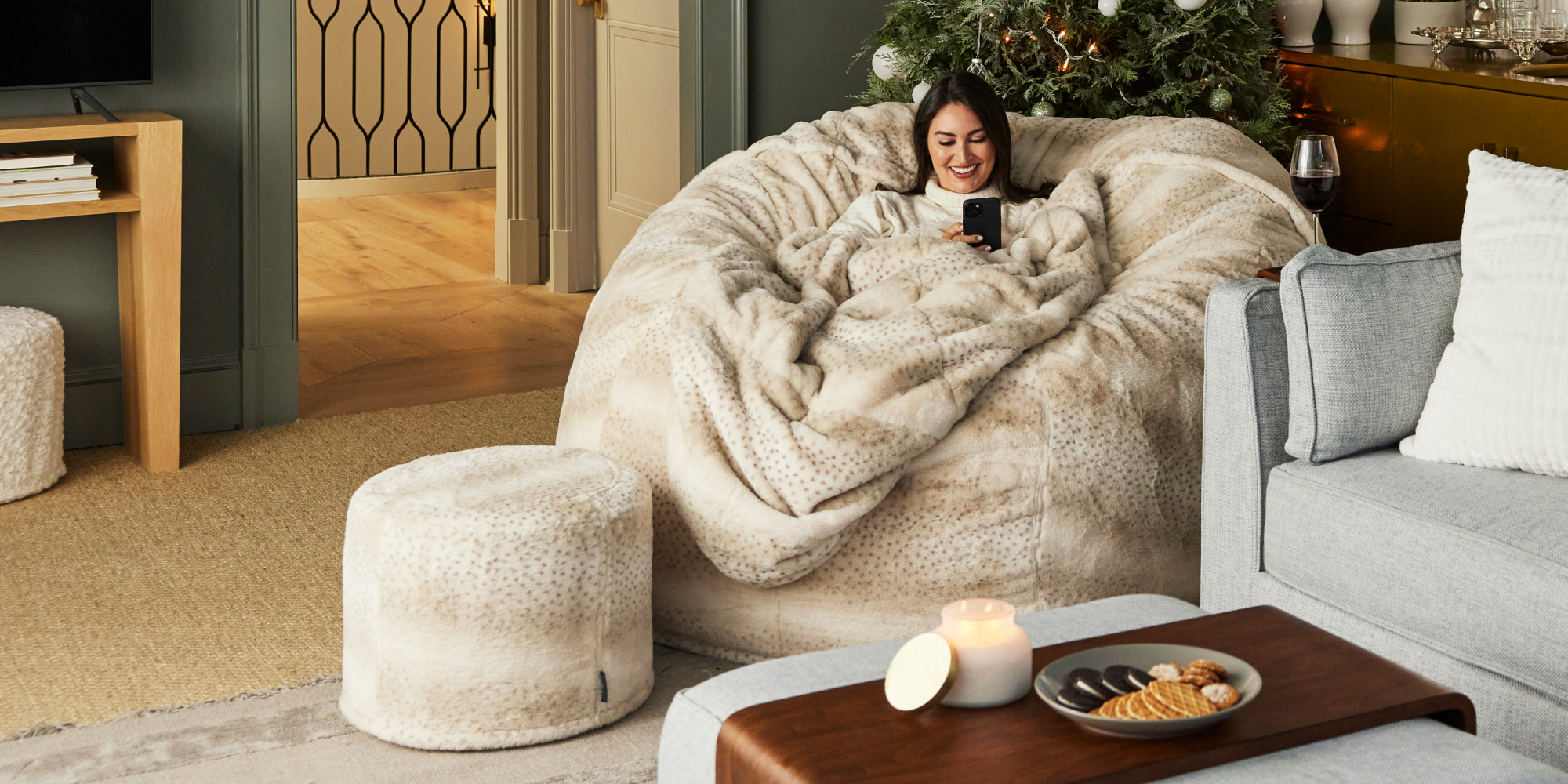 Woman relaxing on a Lovesac Bean Bag chair with a Squattoman and Footsac blanket