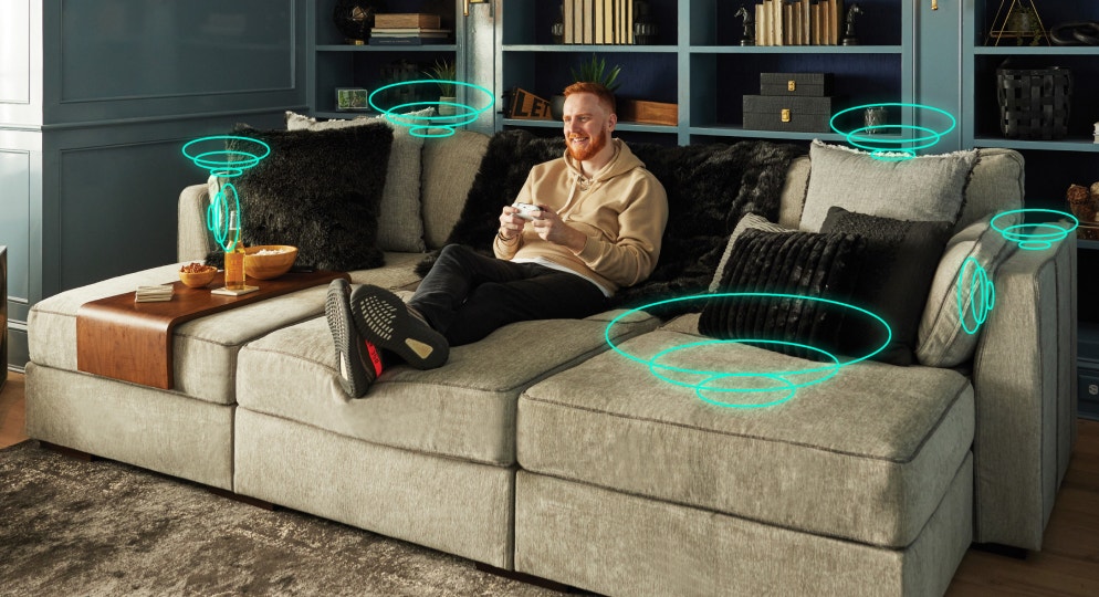 Man playing video games on couch with StealthTech product