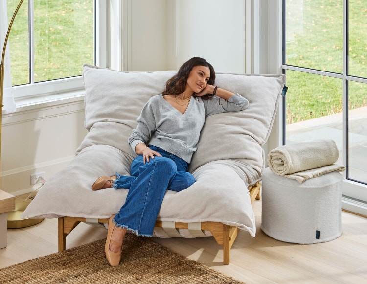 Woman relaxing in her white, Lovesac, PillowSac Accent Chair.