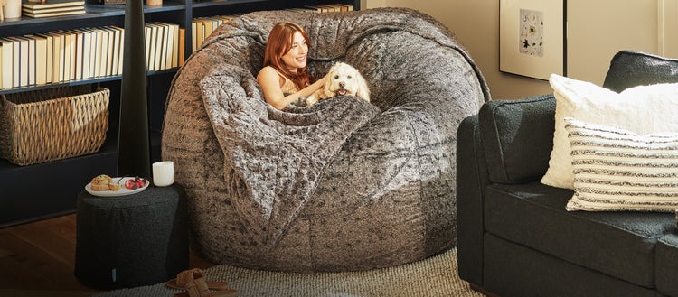 Woman and her puppy cuddling on a Lovesac Beanbag Chair