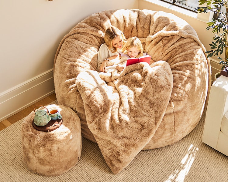 Woman relaxing in her peach colored Lovesac beanbag chair