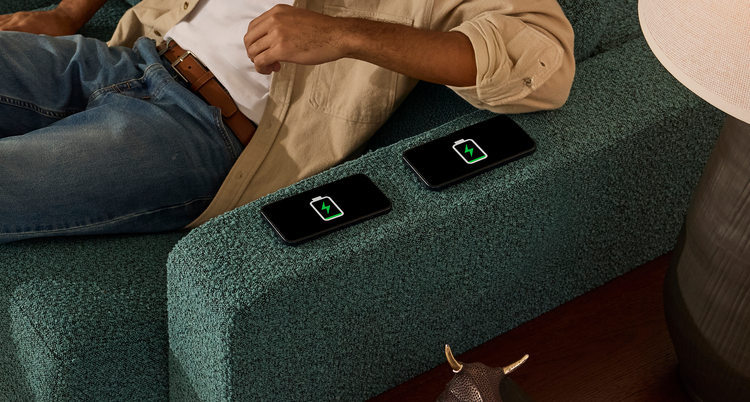 Woman using her Lovesac StealthTech Charge Side built into her sectional couch
