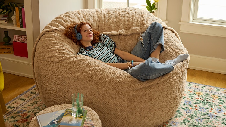 Woman relaxing on her white Lovesac beanbag chair