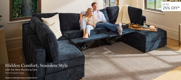 Couple relaxing on a dark blue, Lovesac sectional couch with recliners