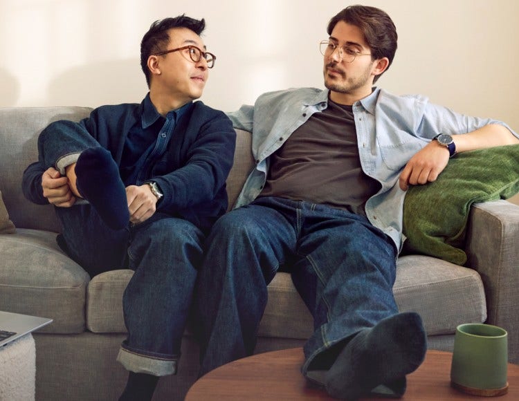 Two guys sitting on a couch in a living room