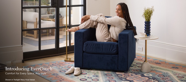 Woman relaxing in a dark blue, Lovesac EverCouch chair in a living space