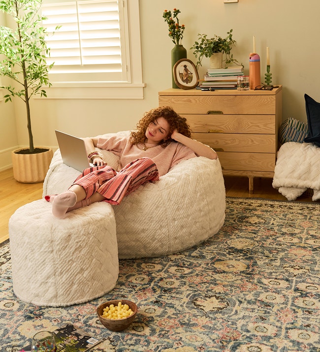 Person relaxing in a Lovesac beanbag chair.