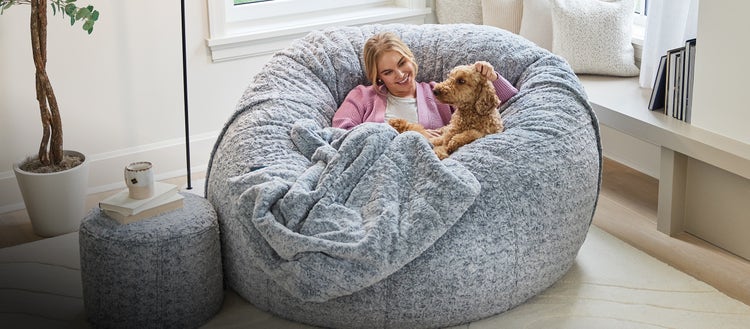 Woman and her puppy cuddling on a Lovesac Beanbag Chair
