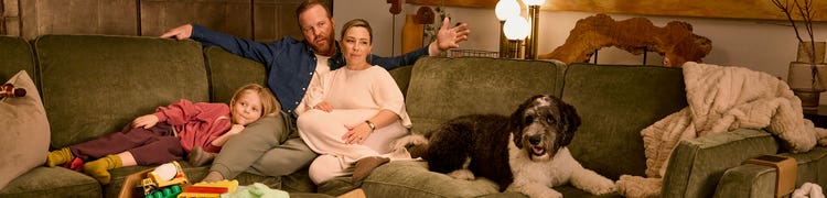 Family and dog enjoying their green, Lovesac, sectional couch