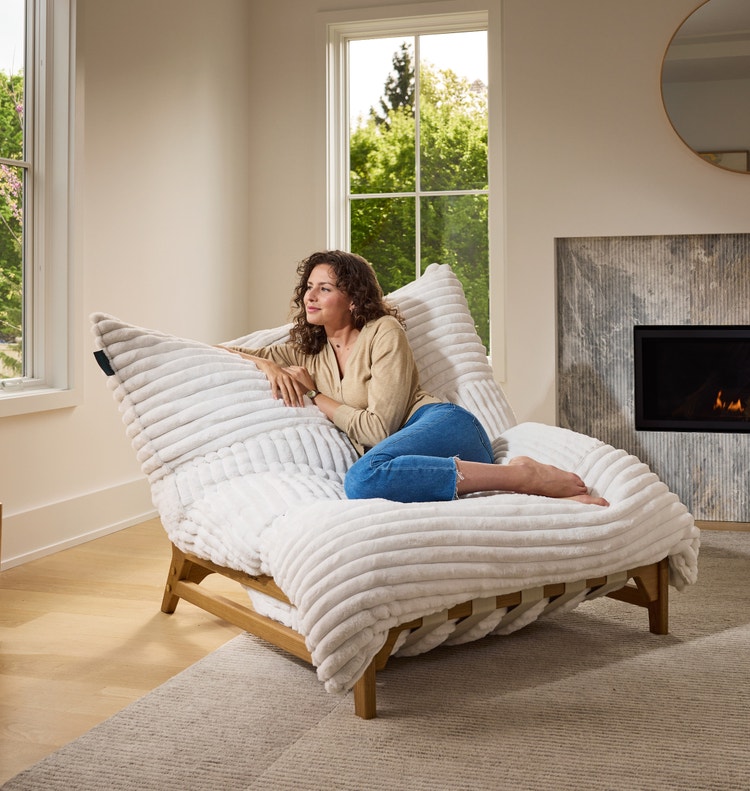 Woman relaxing in her Lovesac Pillowsac Accent Chair in green fabric