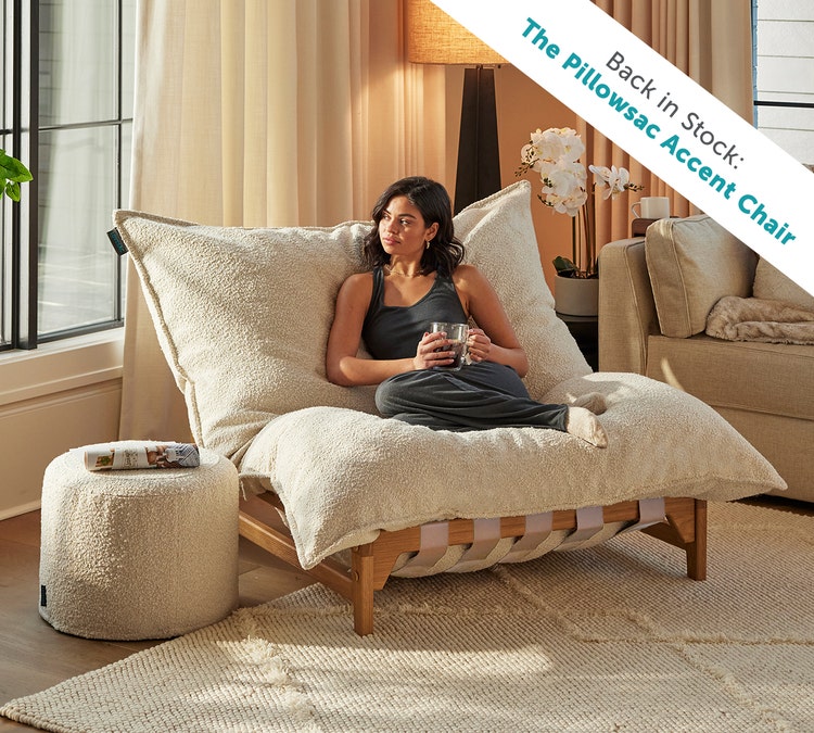 Woman sitting in a Lovesac PillowSac Accent Chair in white fabric