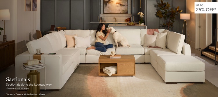 Woman and dog lounging on a beige, Lovesac sectional couch