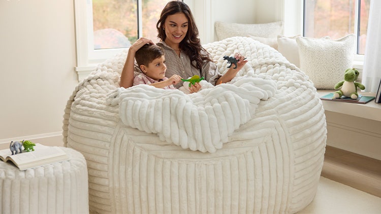 Mom and young son relaxing in their white Lovesac beanbag chair