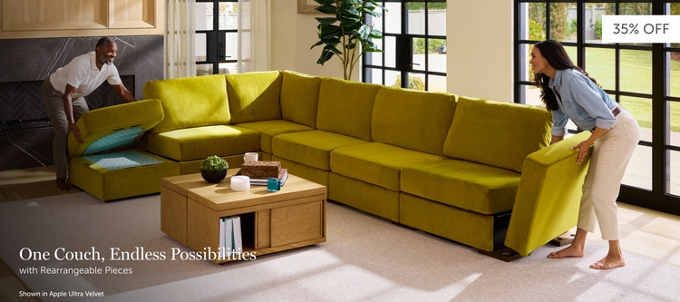 Man and woman setting up a green, Lovesac sectional couch
