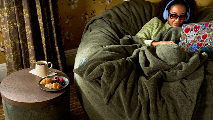 Woman relaxing on her brown Lovesac beanbag chair