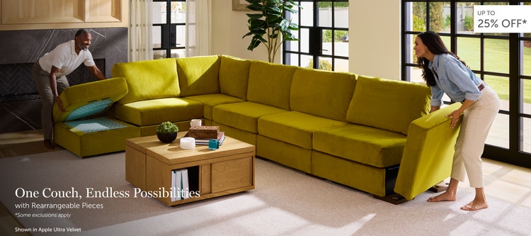 Man and woman setting up a green, Lovesac sectional couch