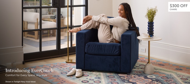 Woman relaxing in a dark blue, Lovesac EverCouch chair in a living space