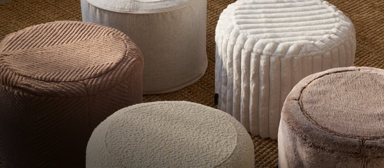 Woman relaxing on a brown, Lovesac, PillowSac Chair with matching ottoman.